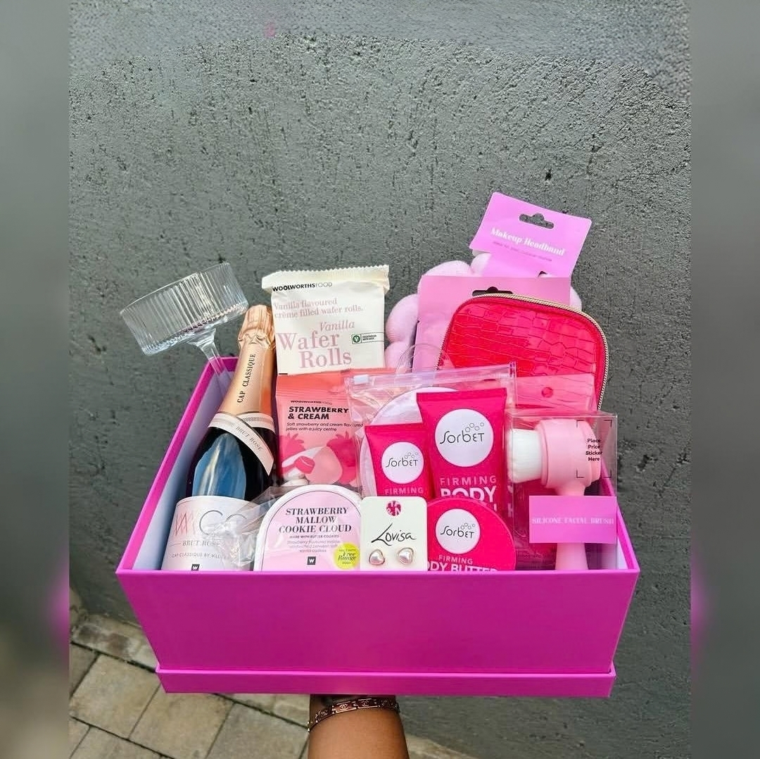 Pink pamper hamper with body-care products, glassware and treats — presentation example